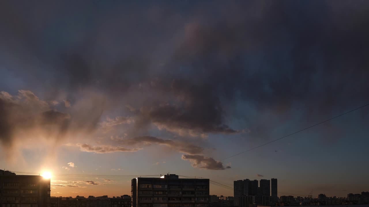 日落时，在高高的房屋后面，天空中快速移动的云视频素材