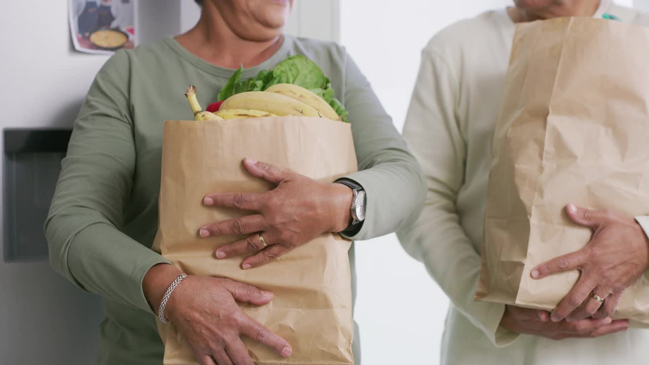 这是一对老年夫妇在自家厨房里打开新鲜食品的4k视频视频素材