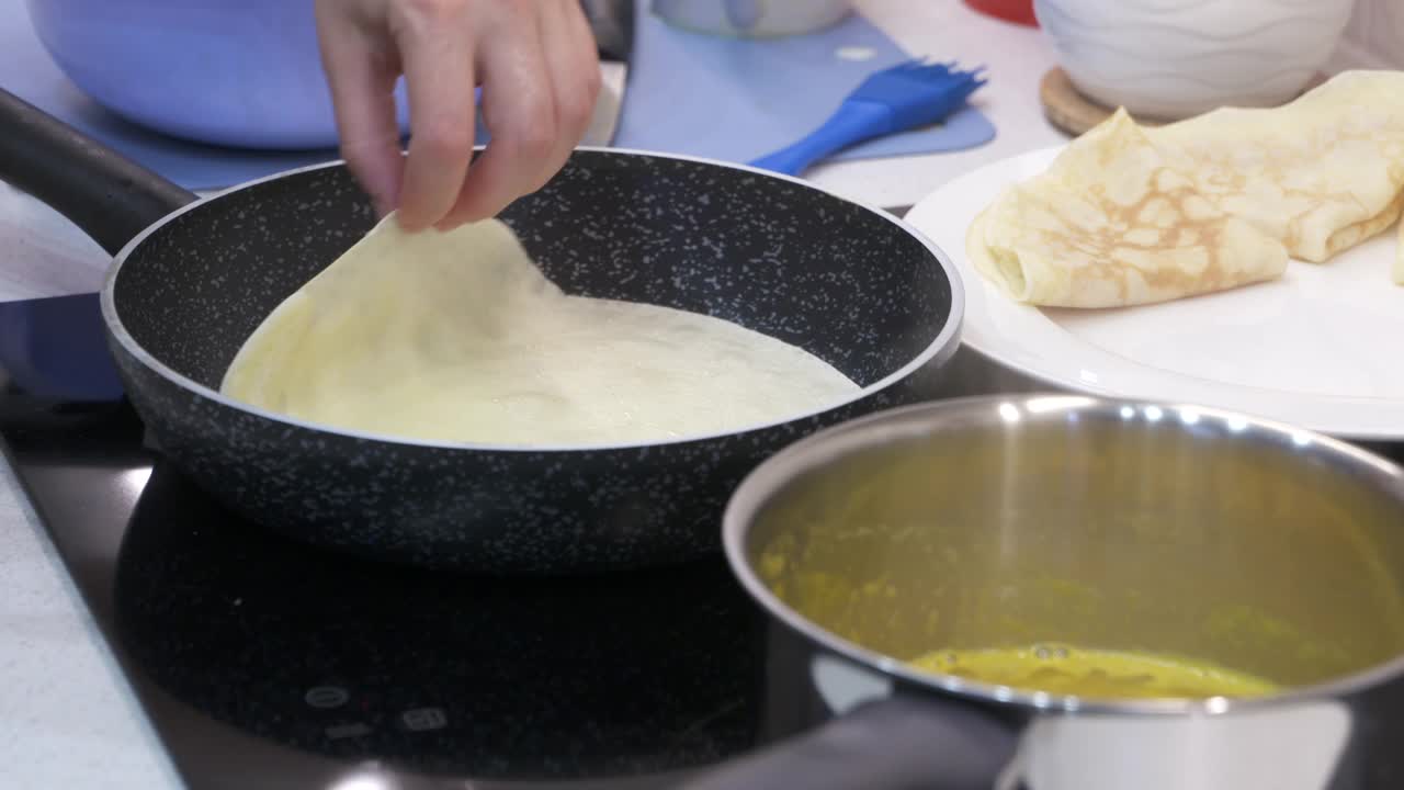 做煎饼的过程，女人在电炉上煎锅做煎饼。视频素材