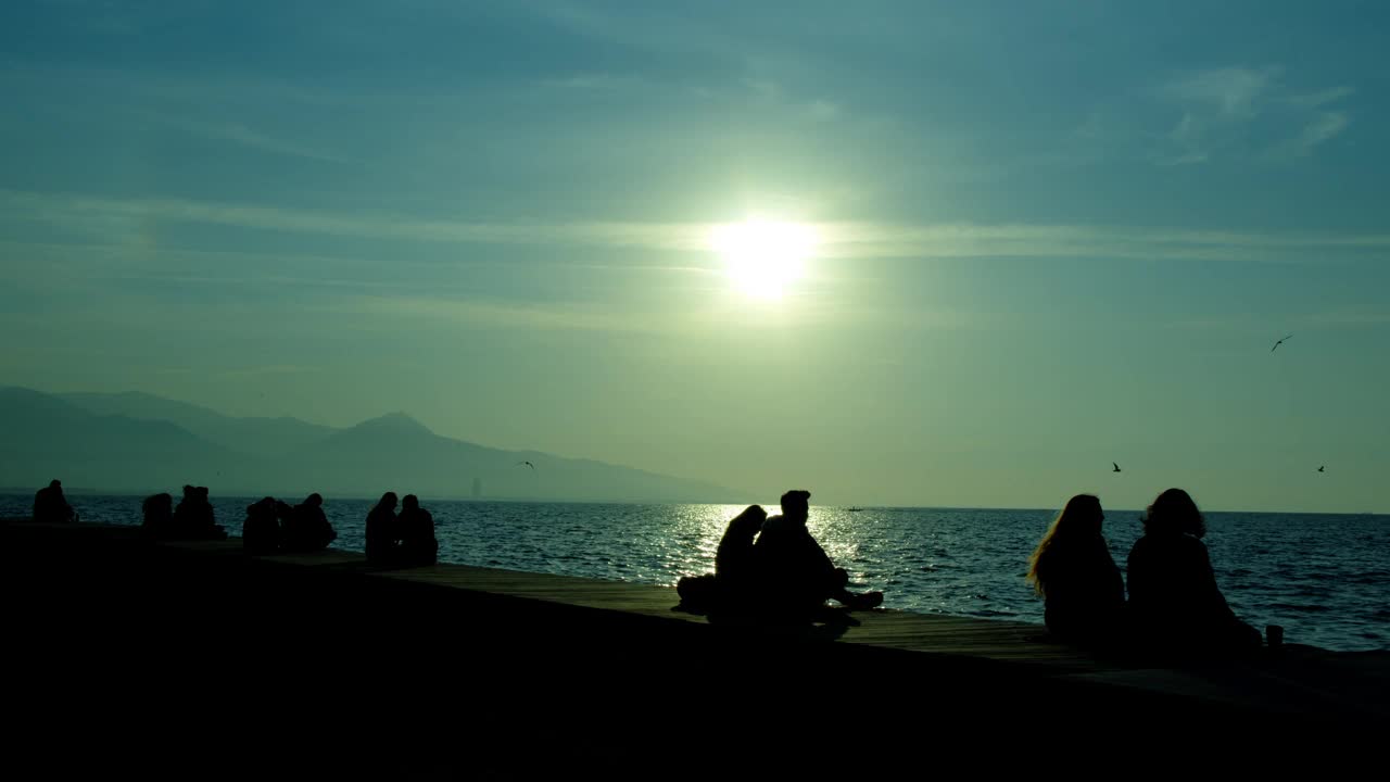 人们剪影附近的海边日落视频素材