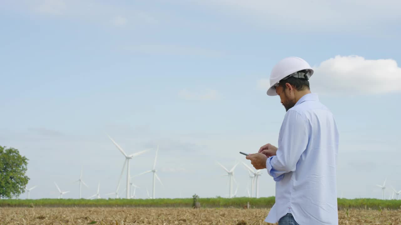 亚洲男性工程师，使用数字平板电脑来验证风力涡轮机的正常和高效运行视频素材