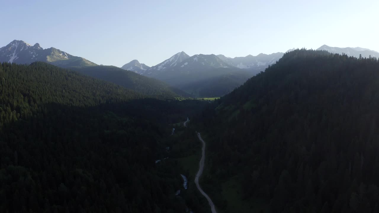 4K Arkhyz山鸟瞰图夏季景观:绿树丘陵森林林地乡村公路山河。晚上光线。旅游目的地，自然公园。北高加索，卡拉查-切尔克西亚，俄罗斯。视频素材