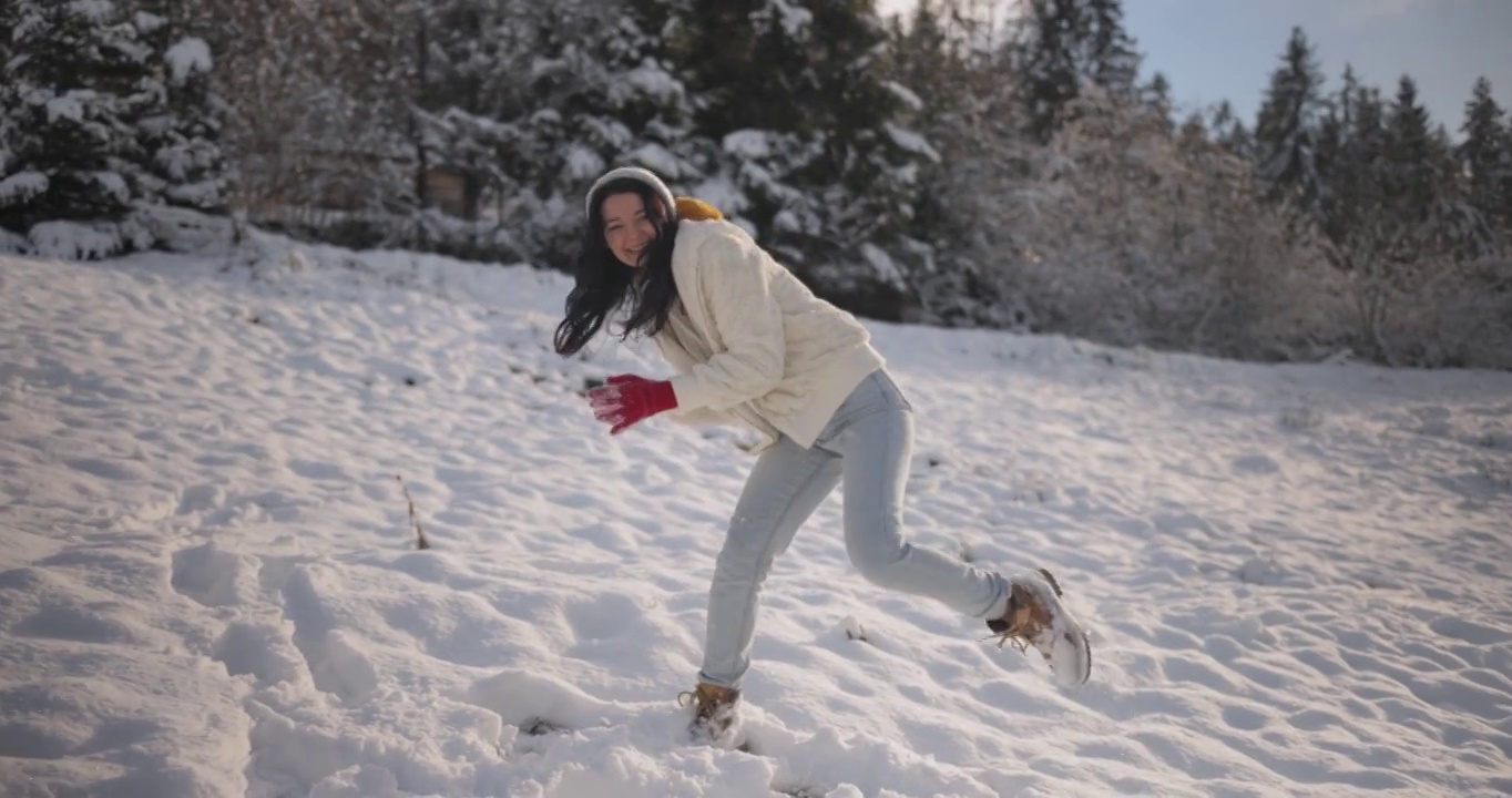 女子玩冬季游戏，在山林户外扔雪球视频素材