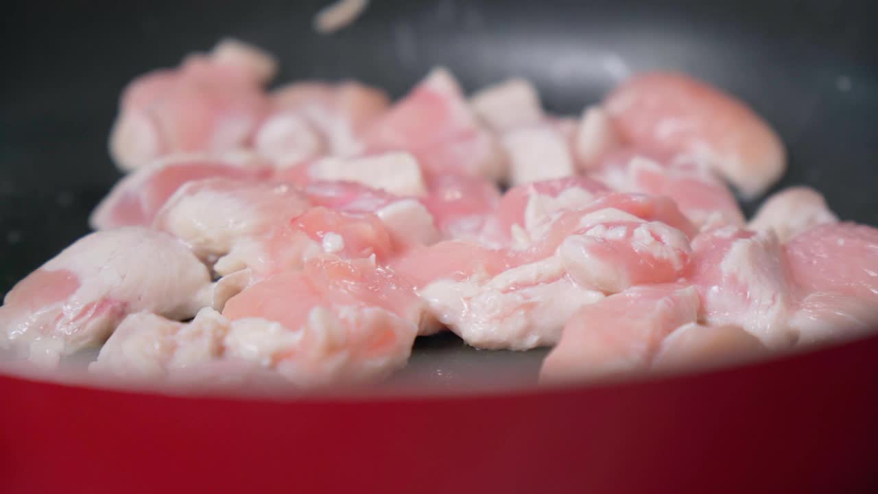 在煎锅中近距离烹饪鸡肉片。在家做饭视频素材