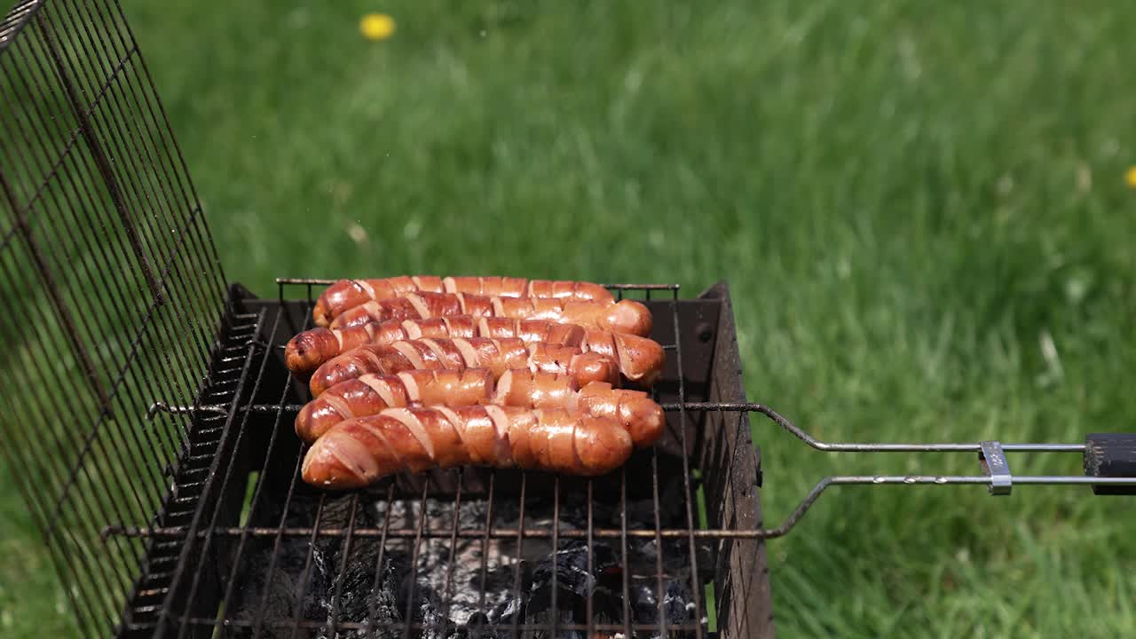 烤好香肠。在夏天烧烤。户外午餐烤香肠。野餐的美味食物。视频素材