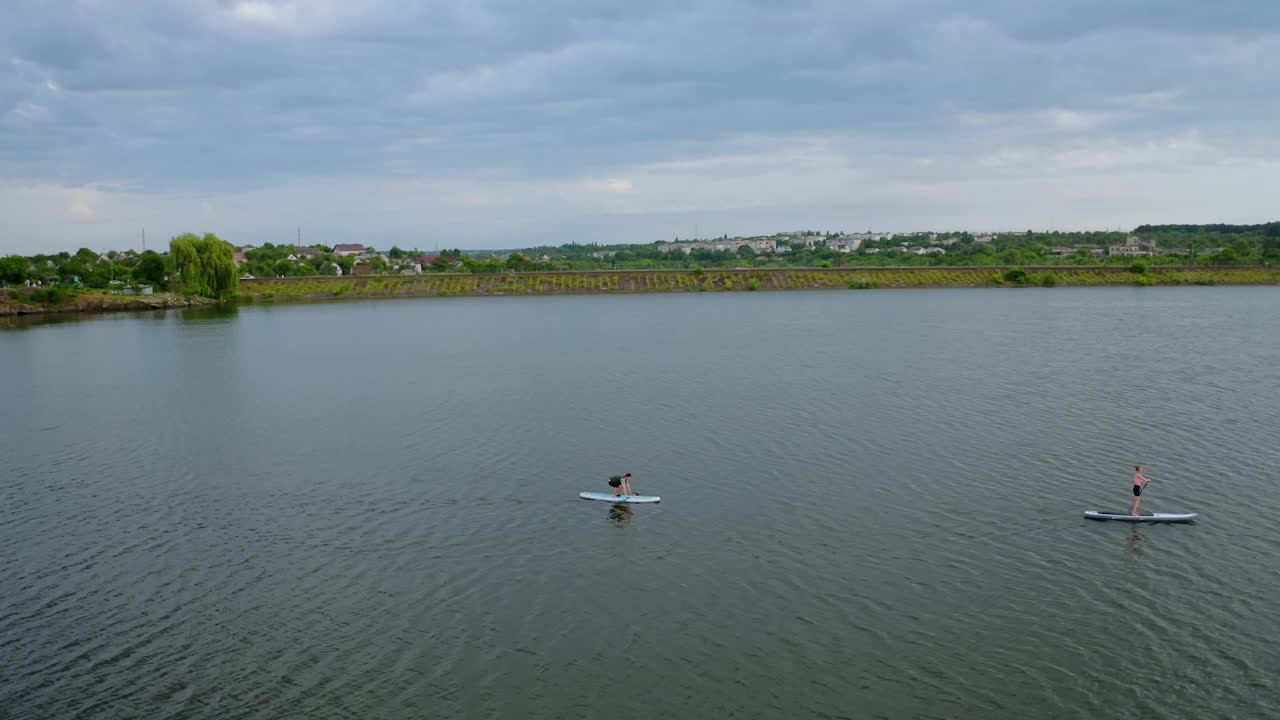 年轻人在水上运动。在河边乘船游览美丽的夏日乡村风光。夏天的休闲时间。鸟瞰图。视频素材