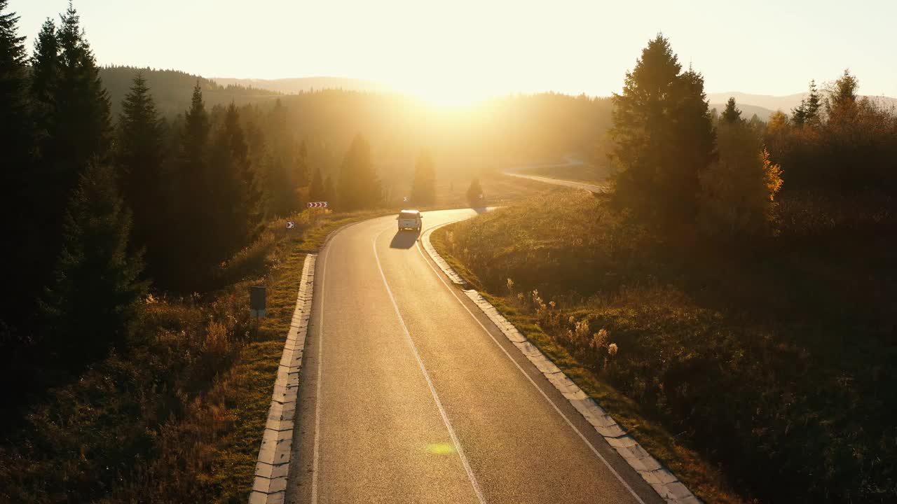 山上的柏油路在夕阳的背景上。视频素材