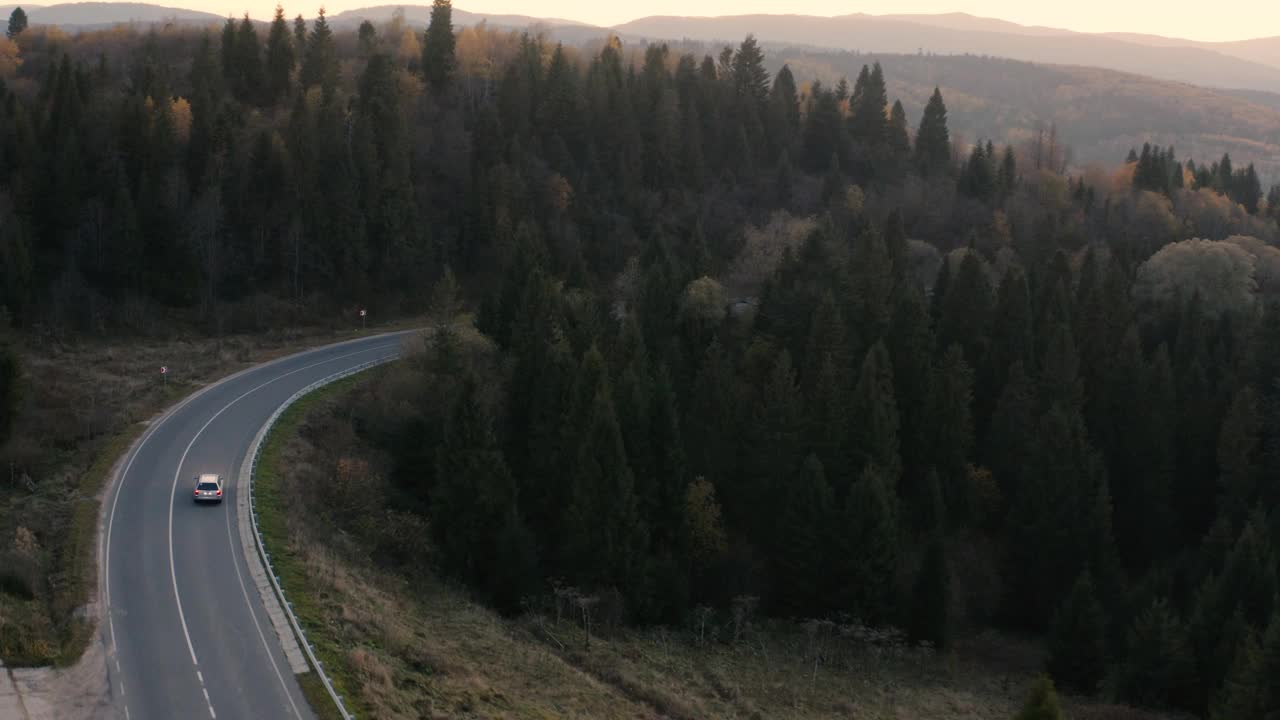 山上的柏油路在夕阳的背景上。视频素材