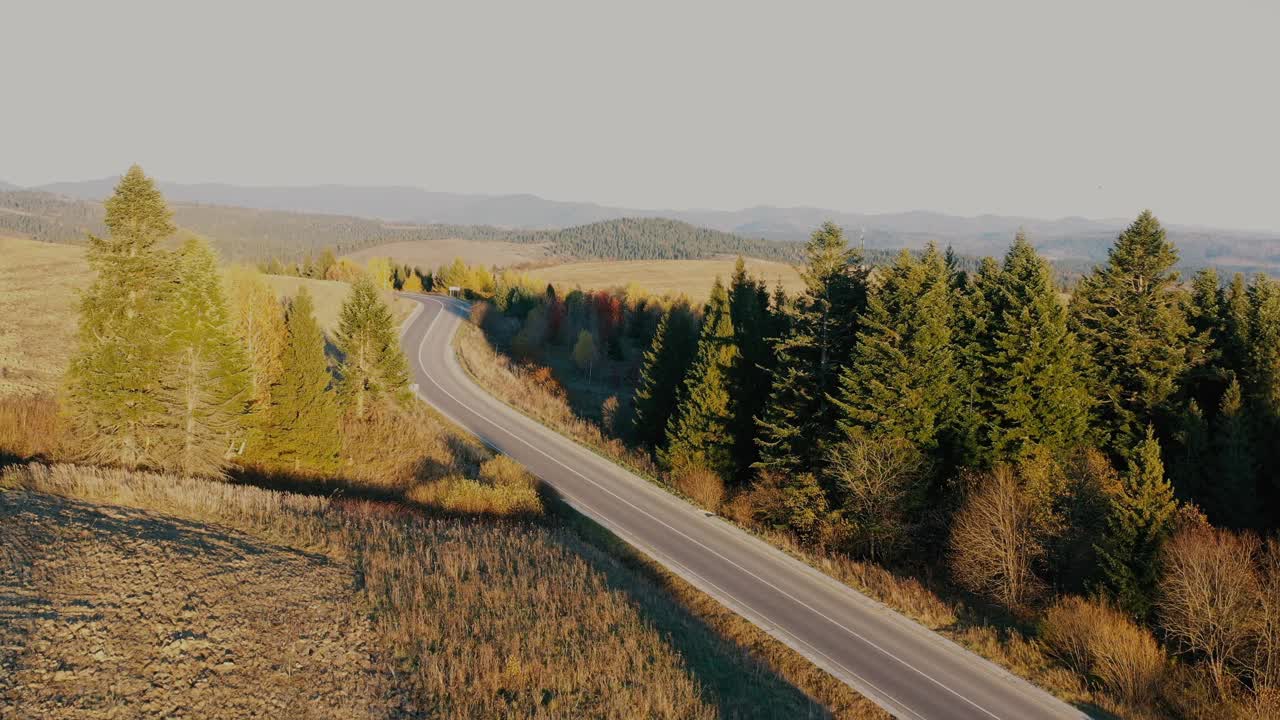 山上的柏油路在夕阳的背景上。视频素材