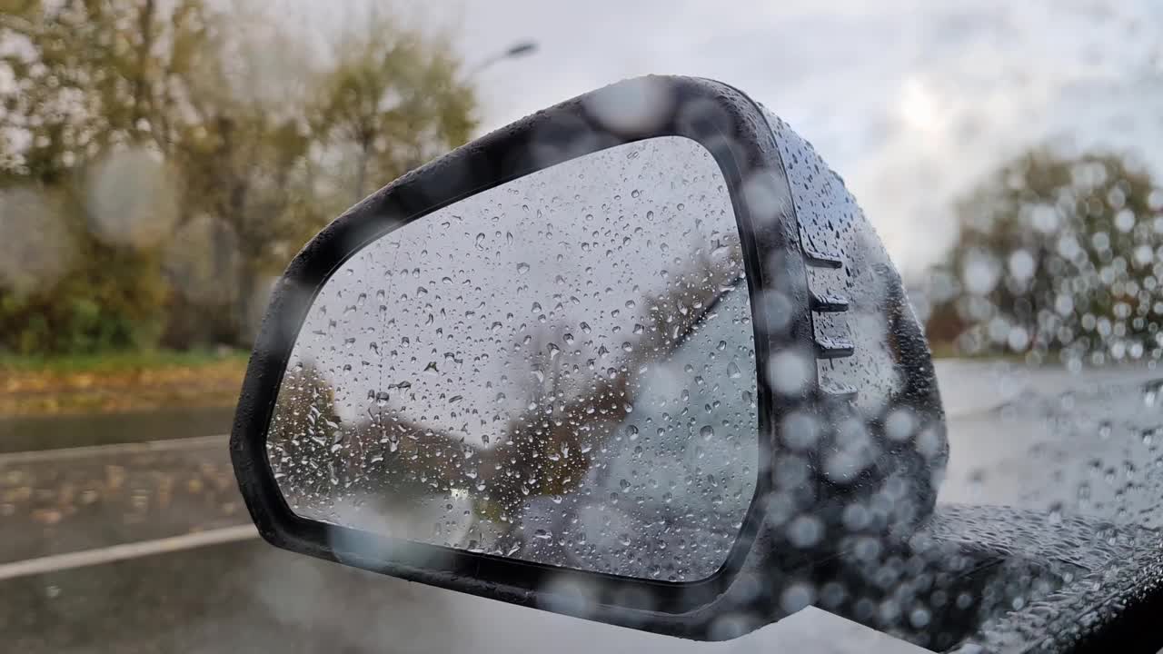 选择性聚焦视图在一辆汽车的侧镜在大雨中。视频素材