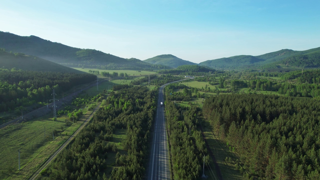 卡车沿着一条风景如画的道路行驶，这条道路坐落在群山和森林之中视频素材