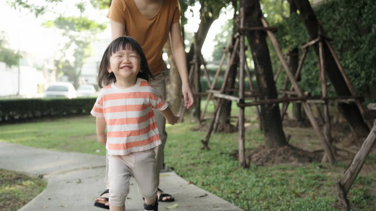 慢镜头:快乐的孩子和妈妈在公园里奔跑。视频素材