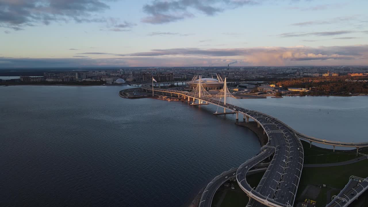 鸟瞰曲线多车道公路横跨涅瓦河。很多车在路上快速行驶。背景是塔桥和泽尼特竞技场。视频素材