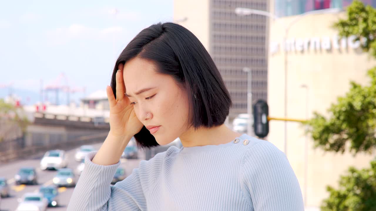 一个美丽的年轻女子看着城市外面繁忙的交通看起来很焦虑的4k视频片段视频素材