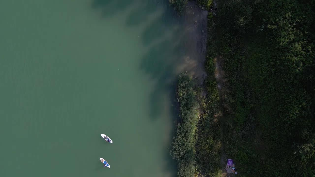 鸟瞰图，人们游泳，休息，日光浴漂浮在滑板上。夏天湖活动视频素材