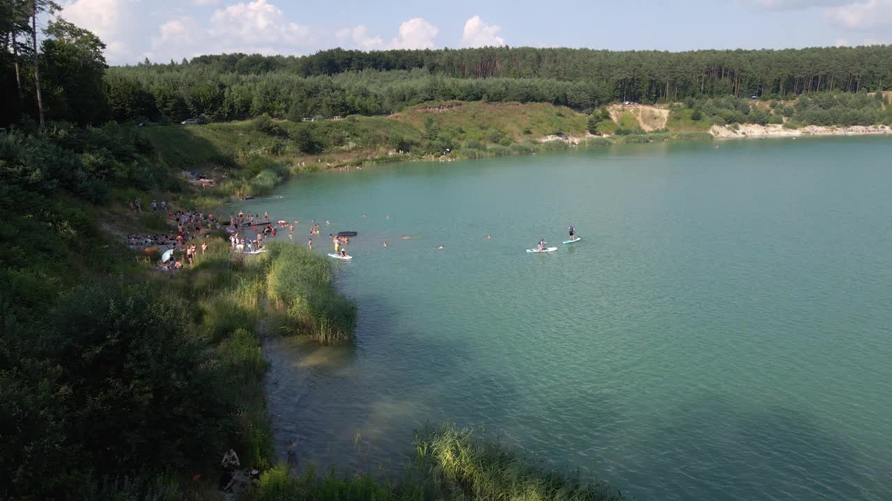 鸟瞰图，人们游泳，休息，日光浴漂浮在滑板上。夏天湖活动视频素材