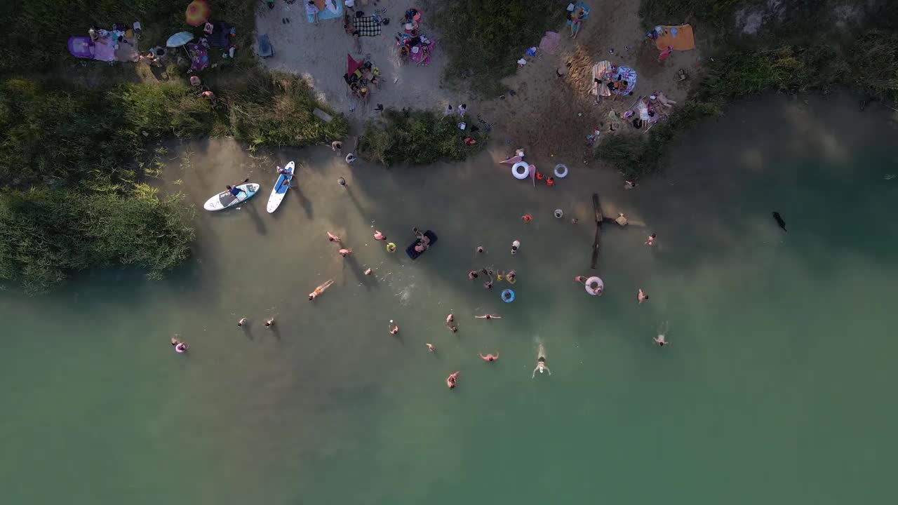 鸟瞰图，人们游泳，休息，日光浴漂浮在滑板上。夏天湖活动视频素材