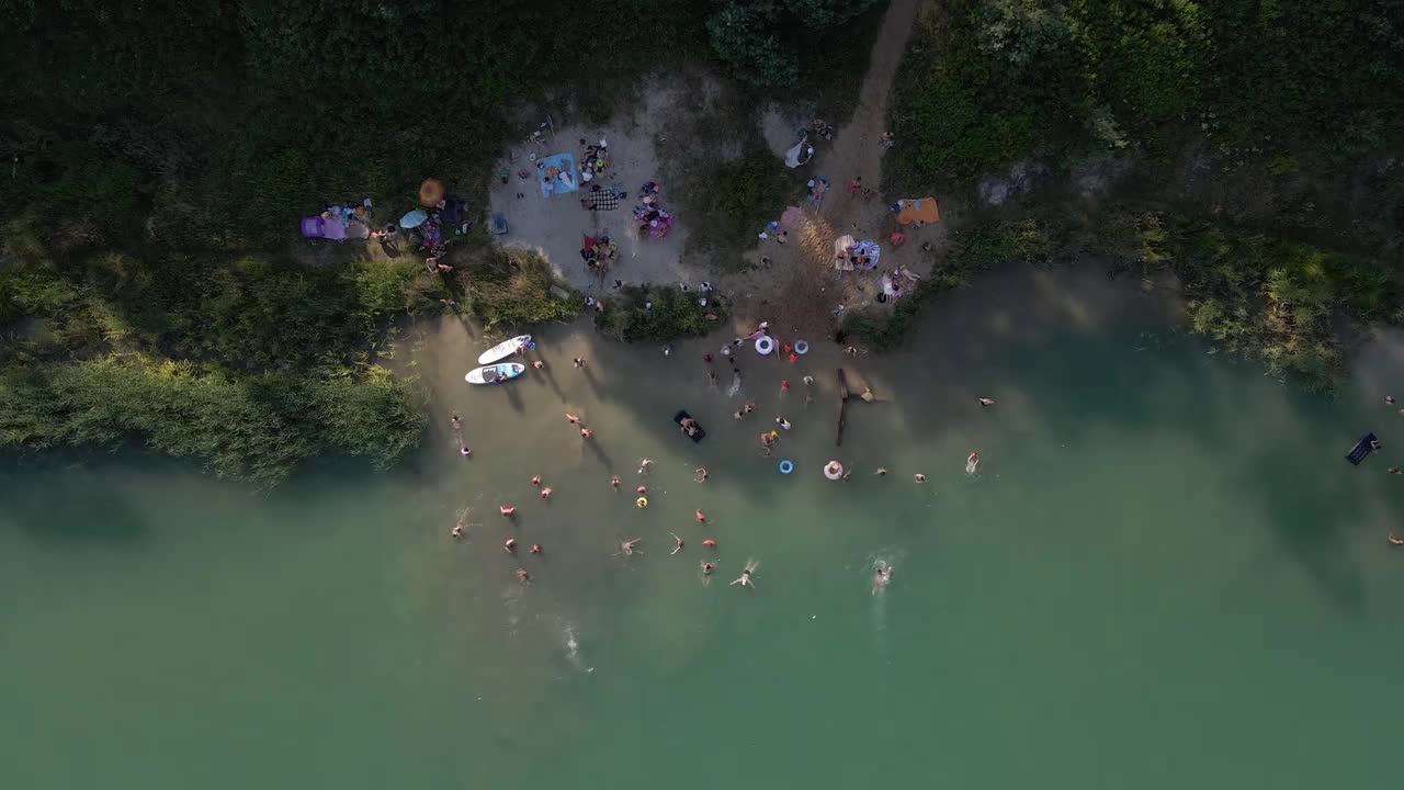 鸟瞰图，人们游泳，休息，日光浴漂浮在滑板上。夏天湖活动视频素材