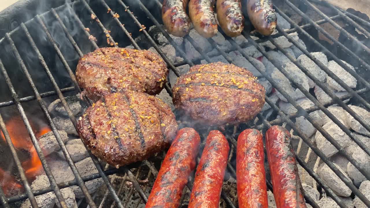 夏天后院烧烤时，在后院烤肉架上烤汉堡和热狗视频素材