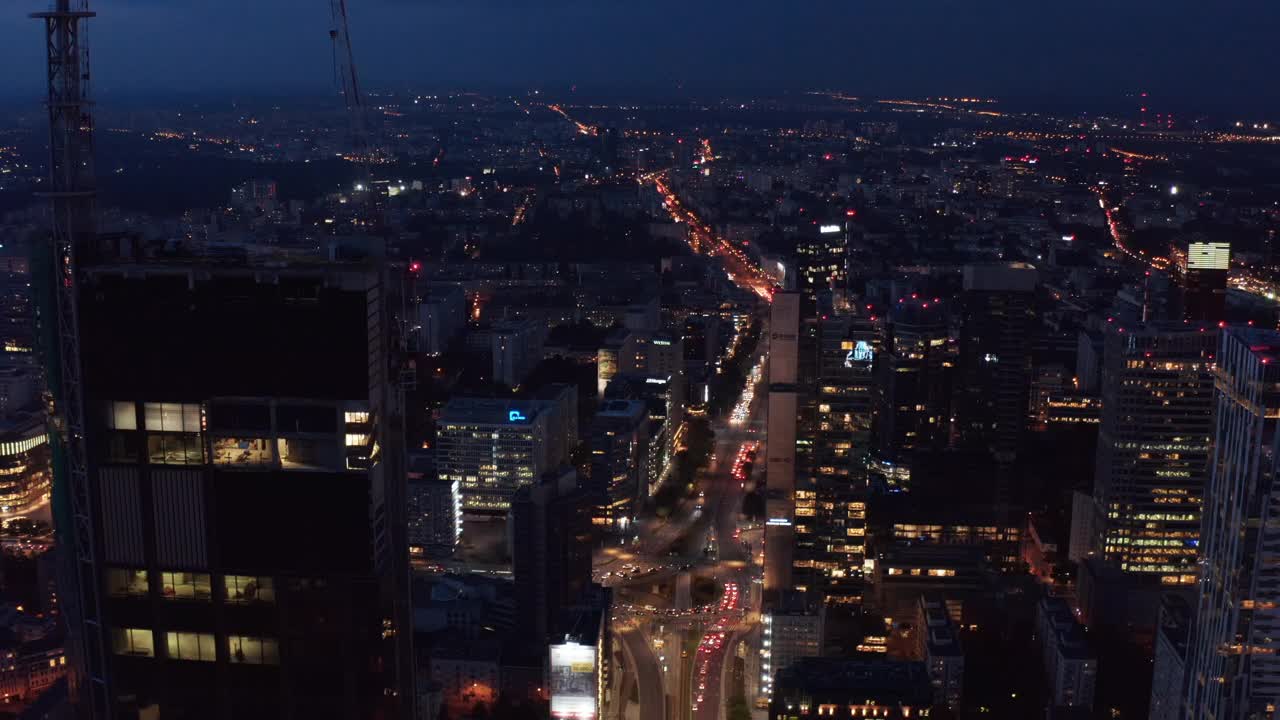 向前飞在摩天大楼周围，显示出下面繁忙的街道。城市夜景的鸟瞰图。波兰华沙视频素材