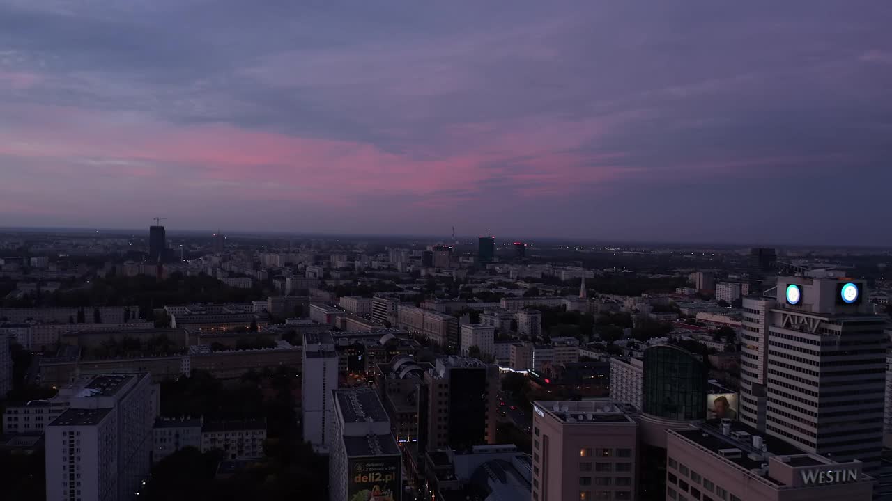 在暮色中，向前飞在昏暗的市区上空。昏暗的夜晚城市场景。波兰华沙视频素材