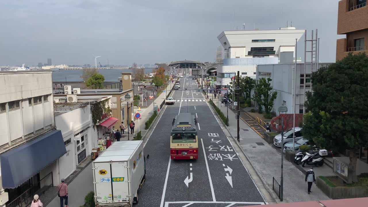 横滨国际客运大楼入口，一辆美丽的红色巴士在路上行驶视频下载