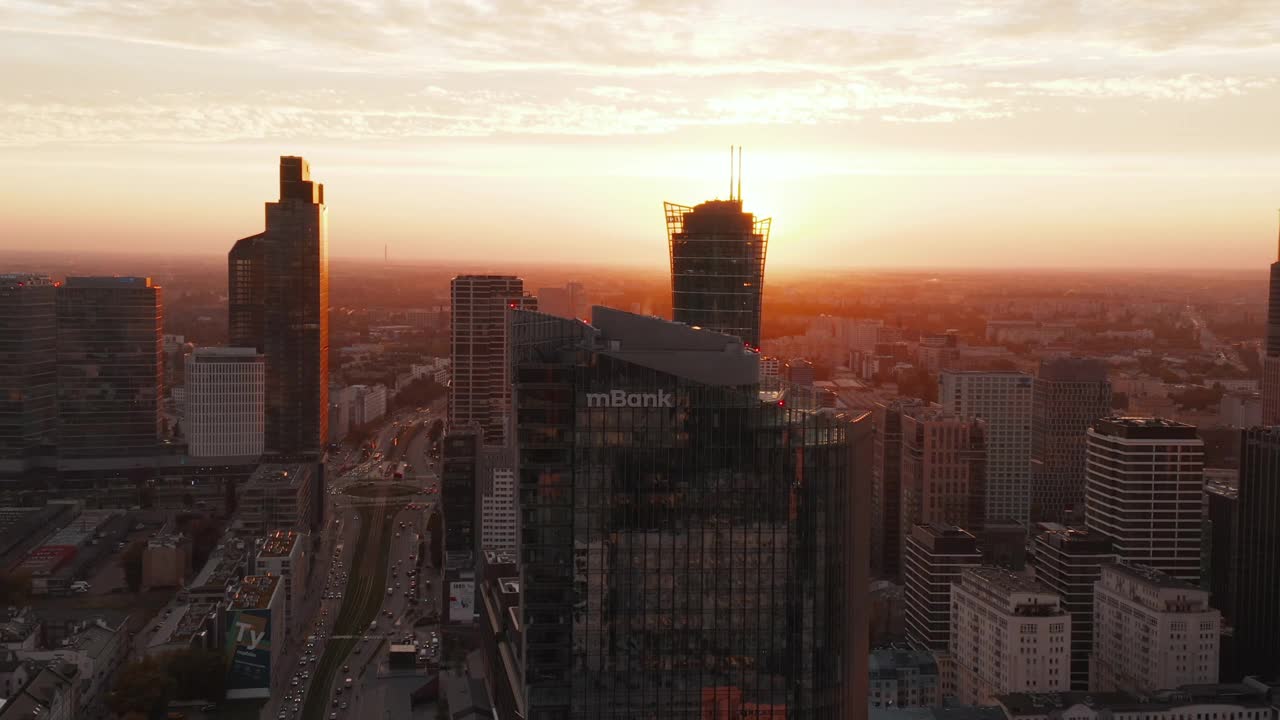 空中拍摄的市中心摩天大楼在日落时的强光下。宽阔街道上的交通。波兰华沙视频素材