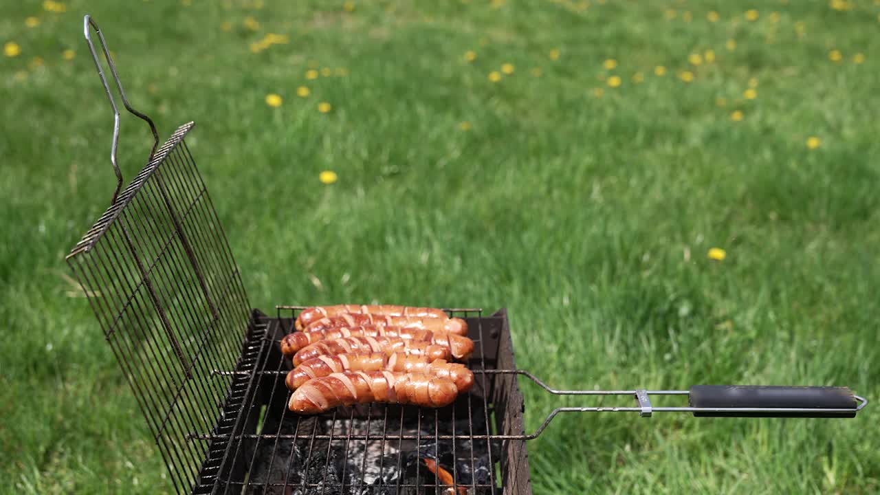 多汁的香肠在烤架上煎着。带脆皮的香肠。烧烤烹饪。视频素材