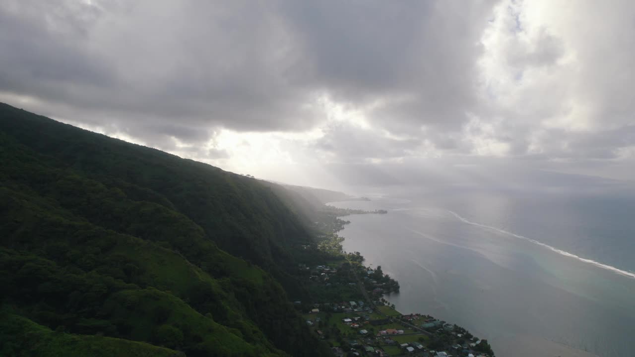 塔希提岛和太平洋海岸线鸟瞰图。穿过火山和云层的阳光。视频素材