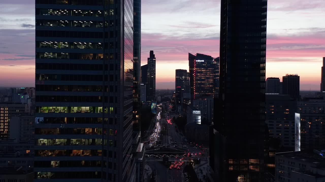 令人惊叹的风景如画的彩色暮色天空背后的市中心摩天大楼。飞机在繁忙的街道上空飞行。波兰华沙视频素材