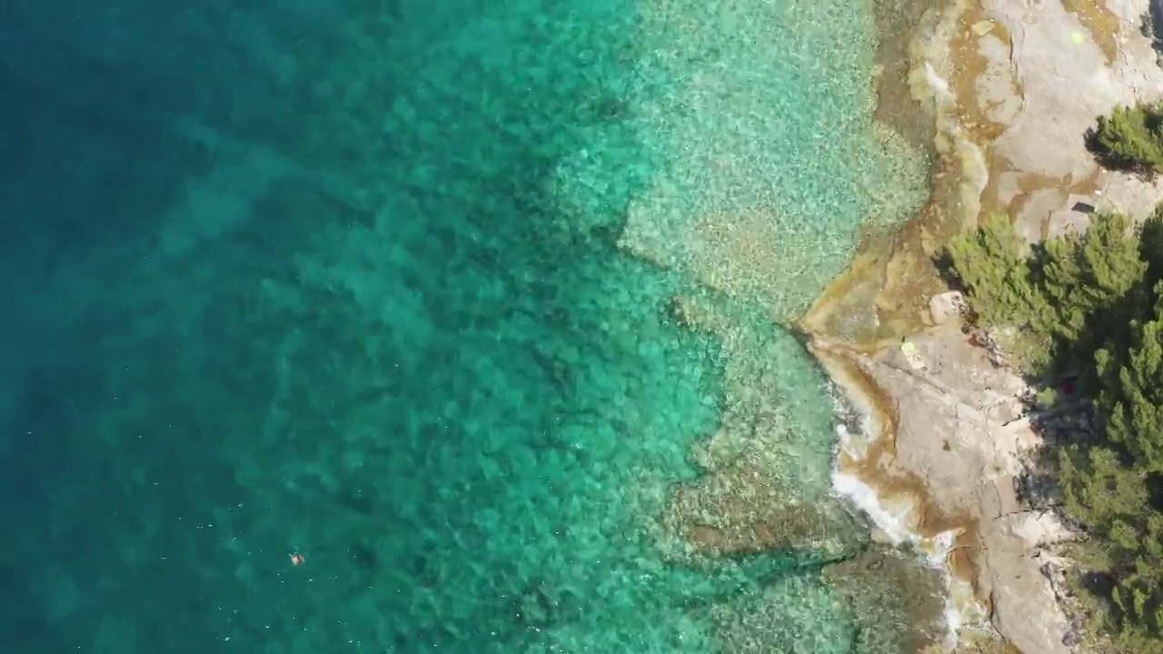 清澈湛蓝的海浪翻滚在空旷的岩石海滩度假村视频素材