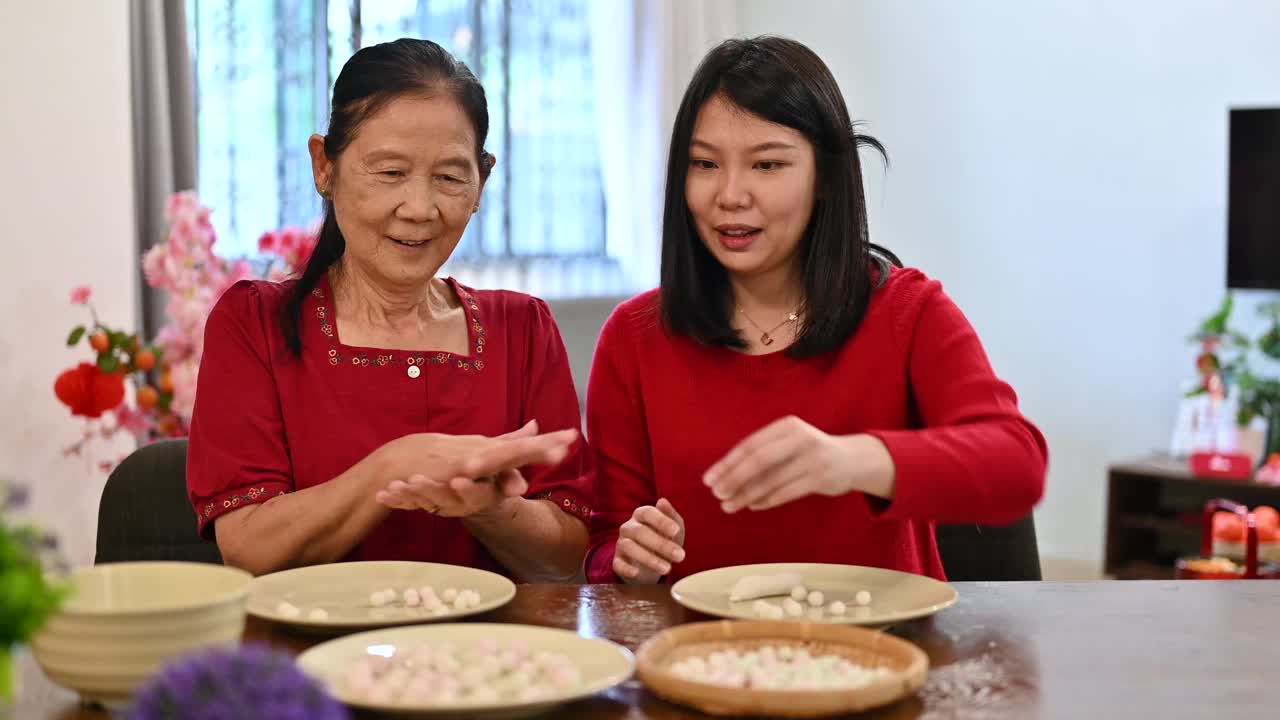 一位亚洲的祖母和她的孙女准备制作汤圆庆祝中国新年视频素材