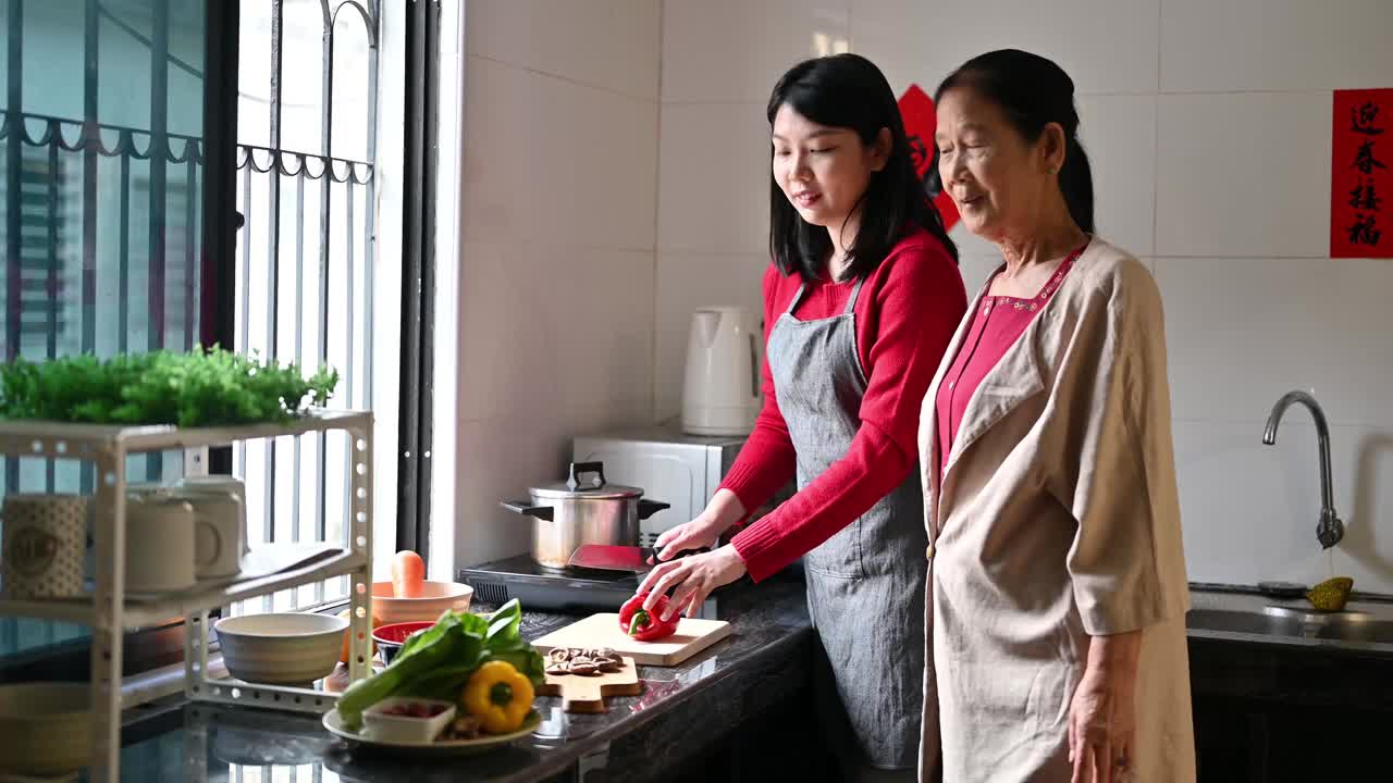 一位亚洲的祖母和她的孙女在为他们的年夜饭准备食物视频素材