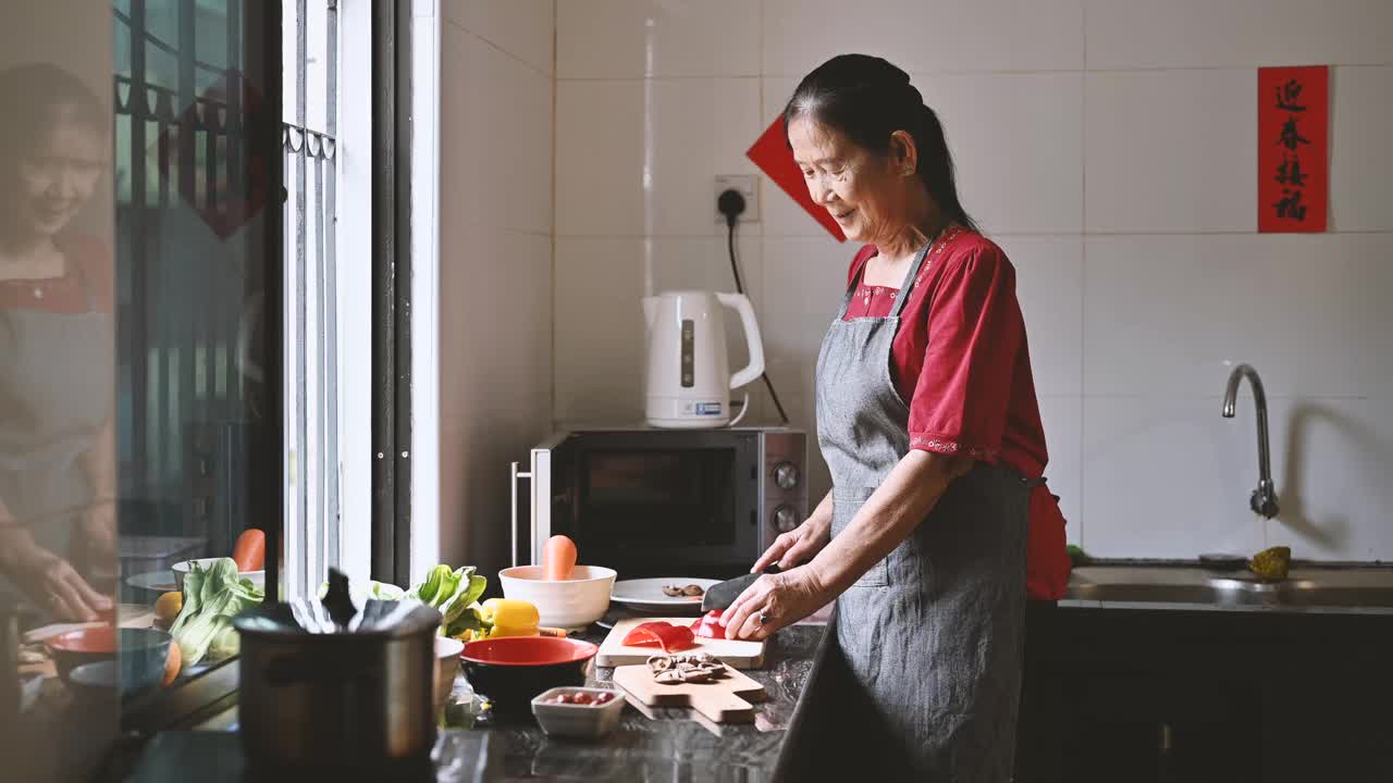 一位亚洲的祖母和她的孙女在为他们的年夜饭准备食物视频素材