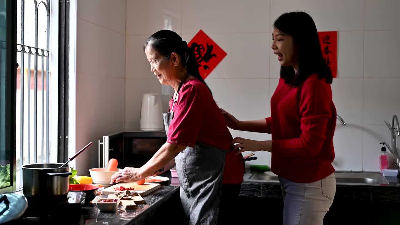 一位亚洲的祖母和她的孙女在为他们的年夜饭准备食物视频素材