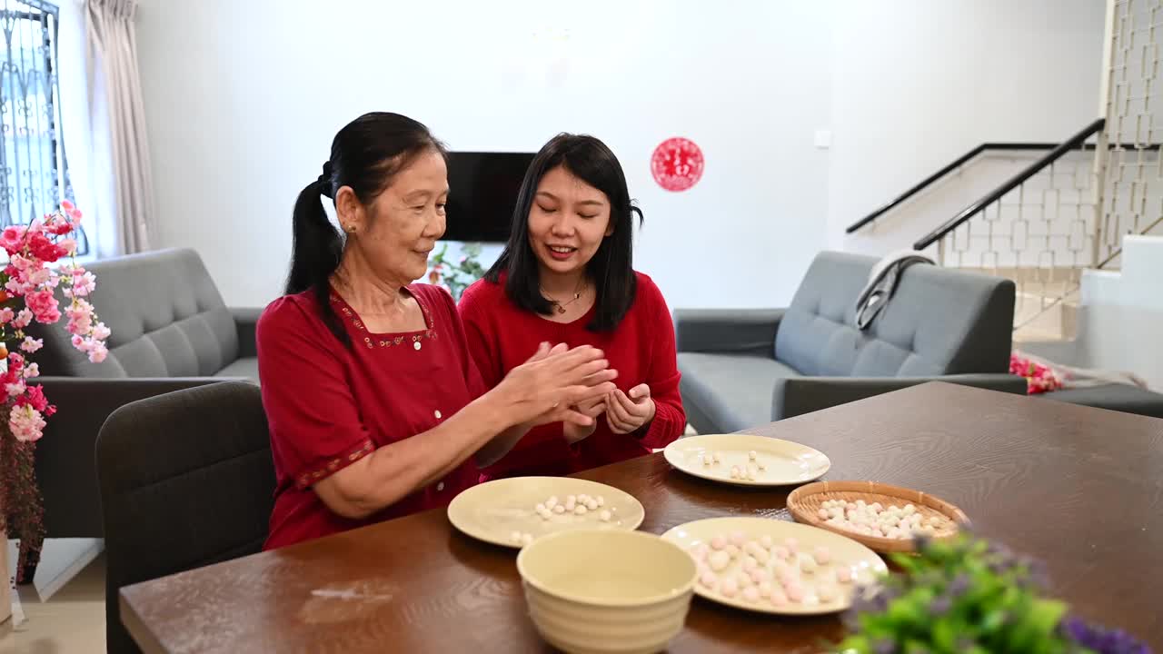 一位亚洲的祖母和她的孙女准备制作汤圆庆祝中国新年视频素材