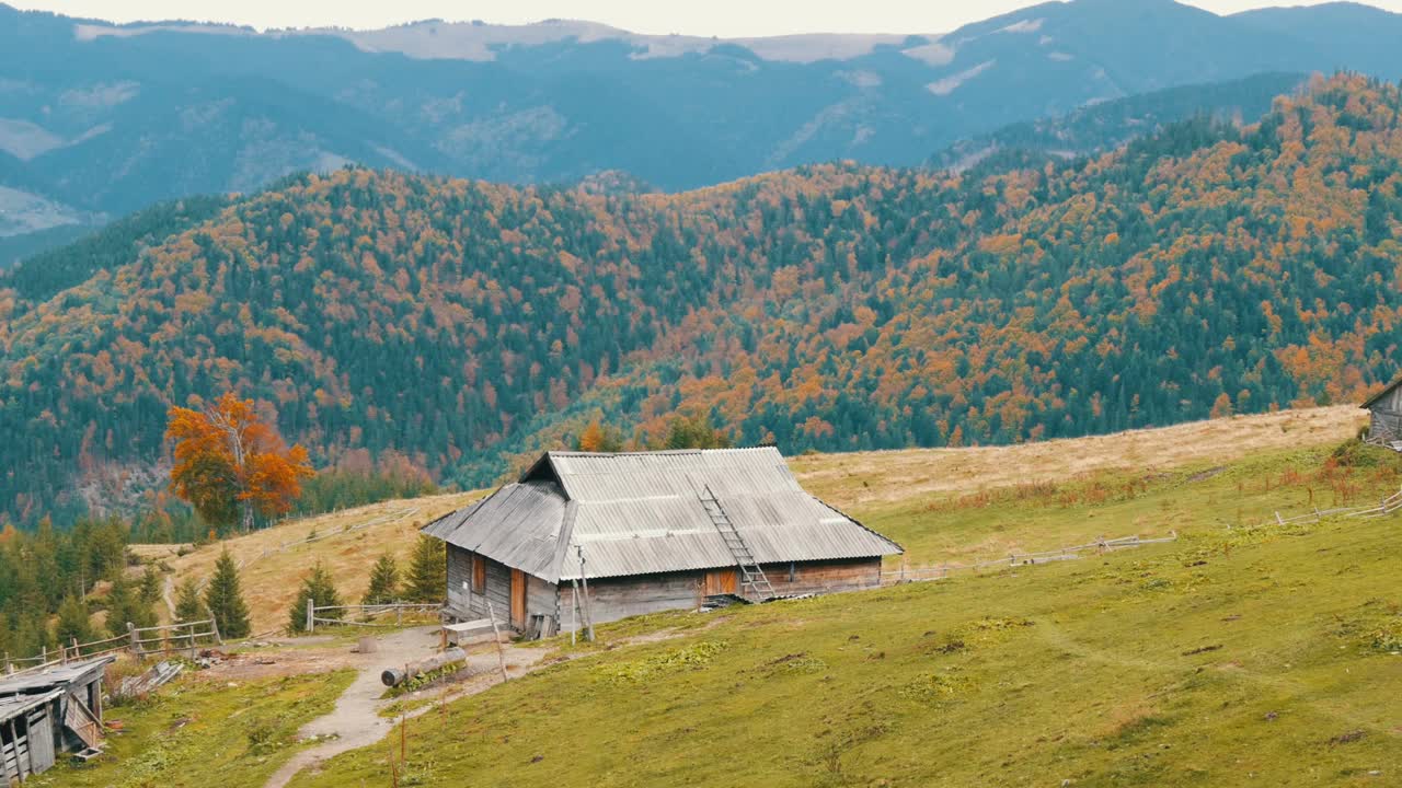 秋天风景如画的喀尔巴阡山脉为背景的牧羊人所建的旧木制废弃木屋。破败的废弃建筑视频素材