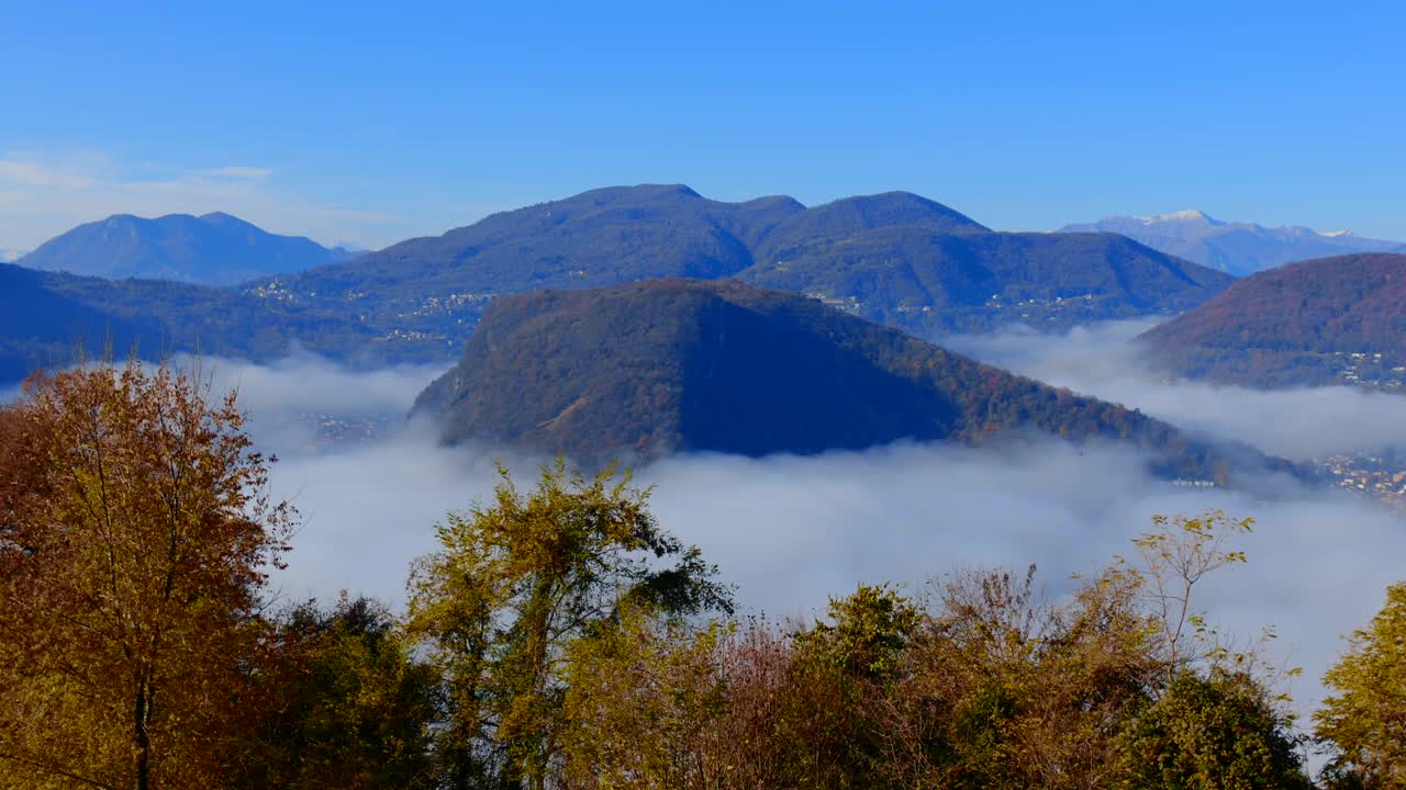 在一个阳光明媚的日子里，在高山湖卢加诺的云海与山景视频素材