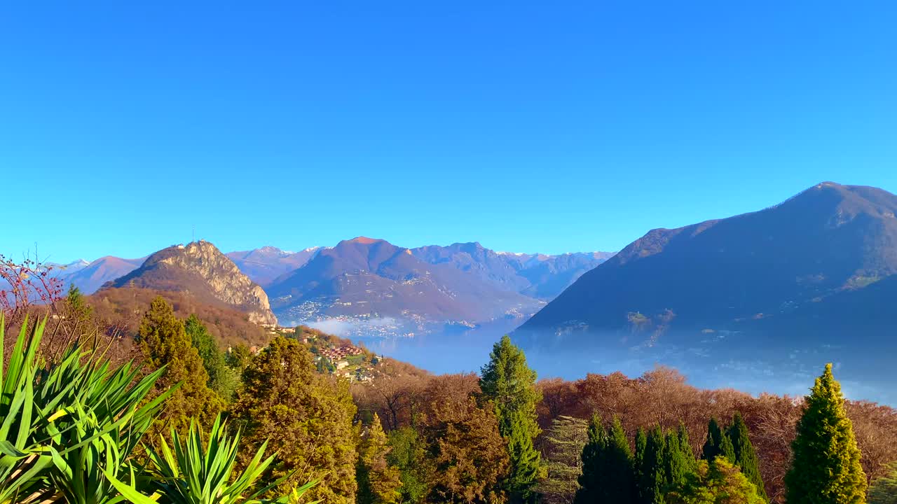 在阳光明媚的秋日里，卢加诺市和卢加诺高山湖的全景视频素材