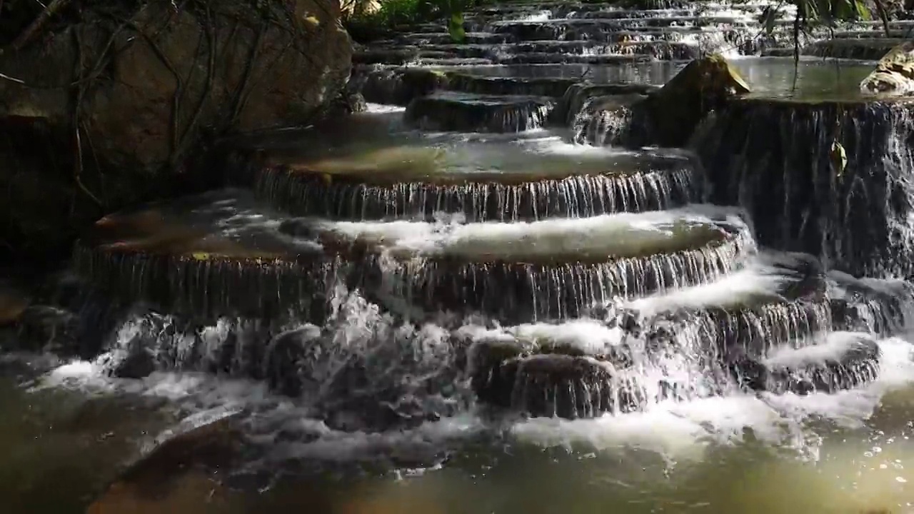 瀑布在岩石上流过，形成了一个美丽的水层。视频素材