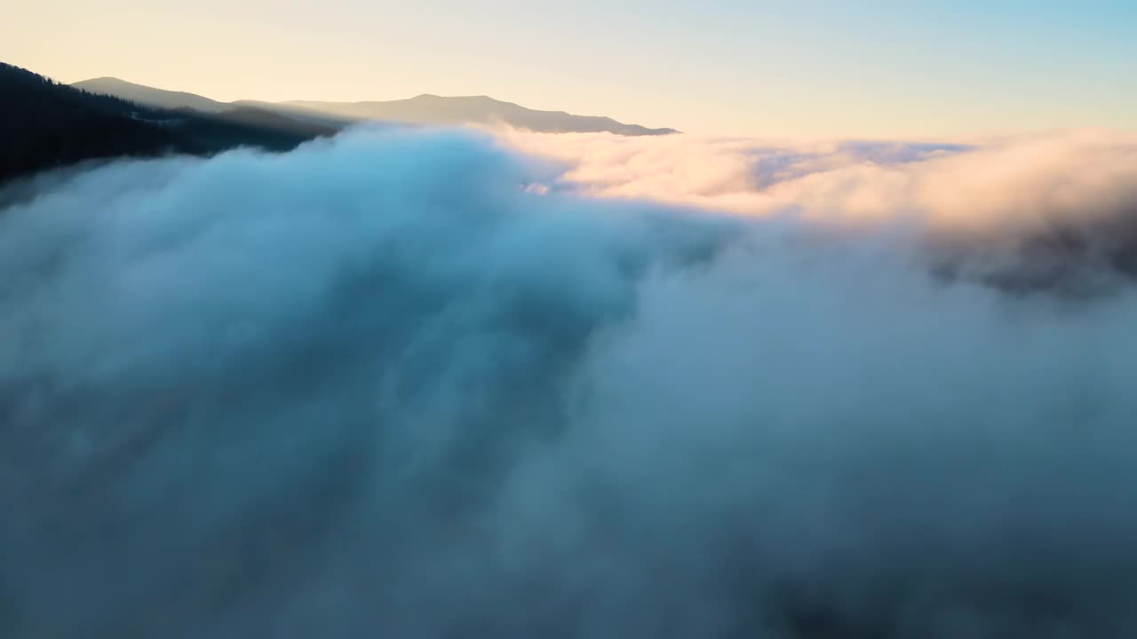 鸟瞰图的景观之上雾快速移动的云覆盖山脉在日落视频素材