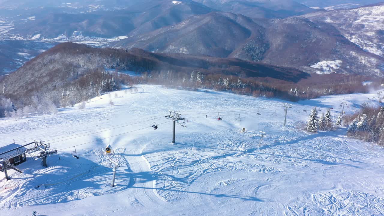 在阳光明媚的冬日早晨，滑雪场滑雪坡的鸟瞰图视频素材