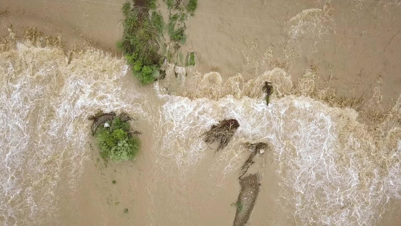 鸟瞰图:在春季暴雨期间，河水泛滥，河水浑浊。视频素材