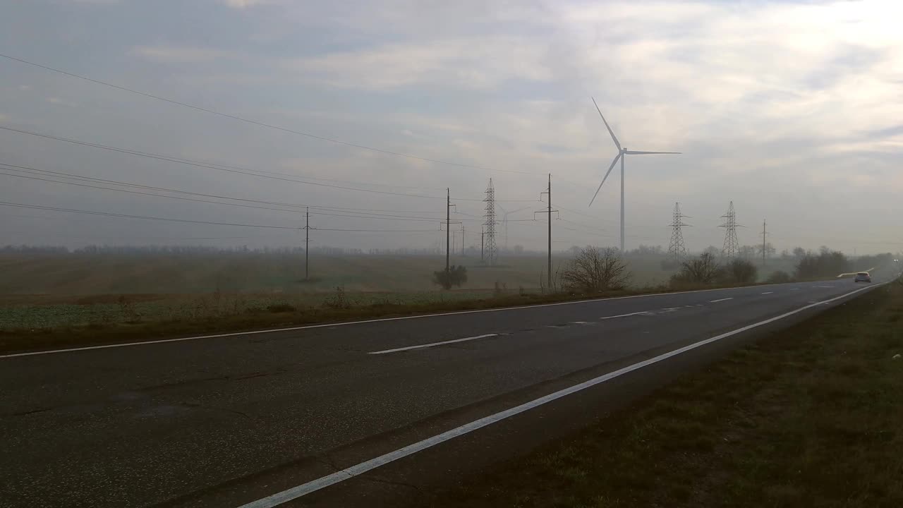 风力发电机在现场。多雾的天气。路。视频素材