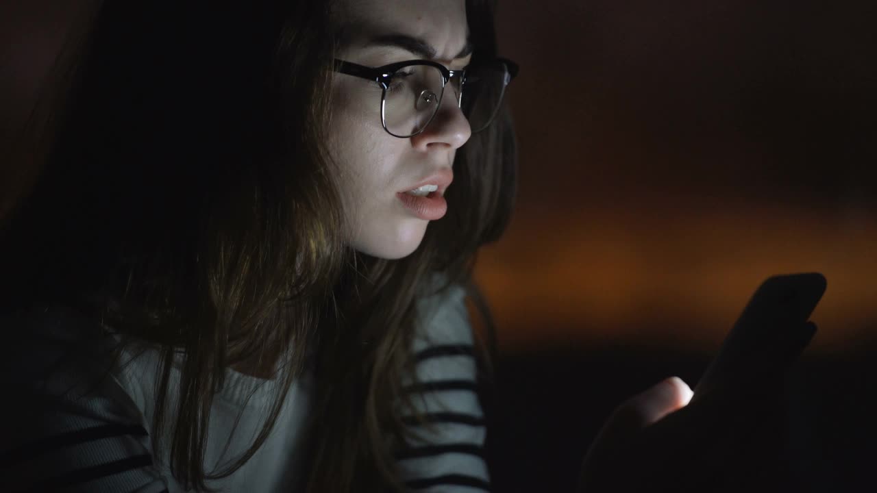 年轻女子一边喝咖啡一边用智能手机视频素材