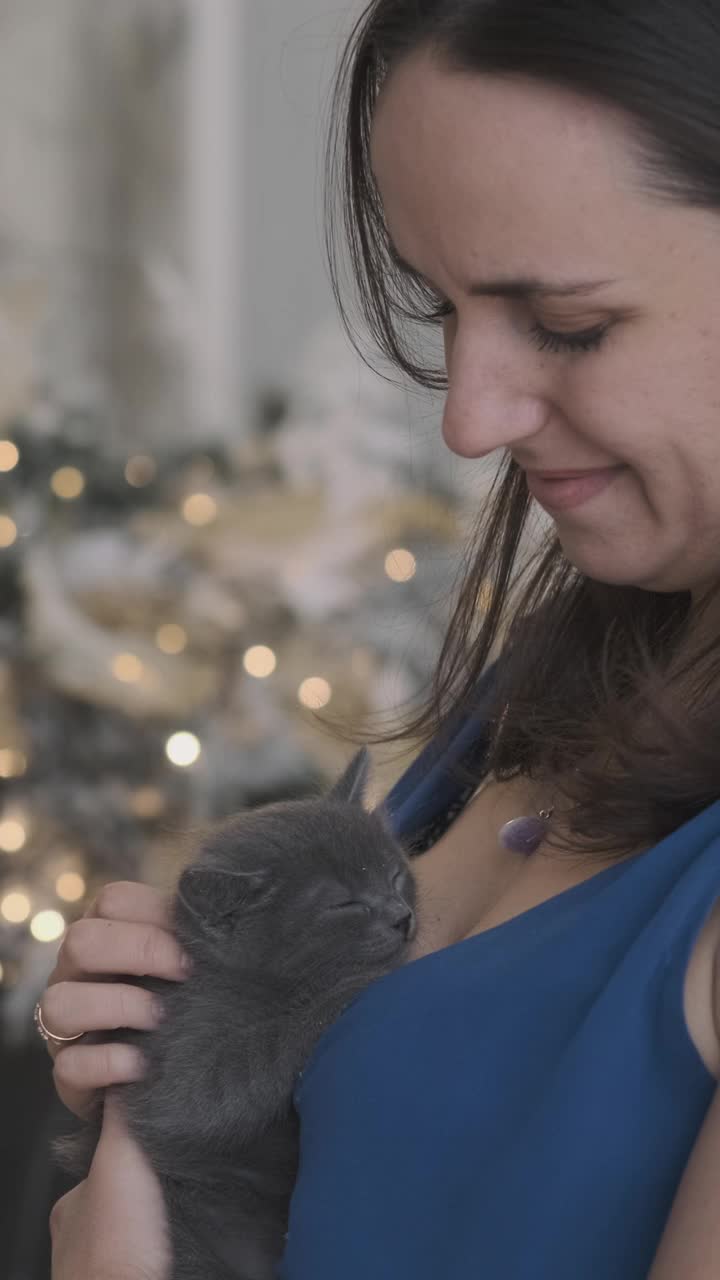 漂亮女人抱着小猫在圣诞树旁视频素材