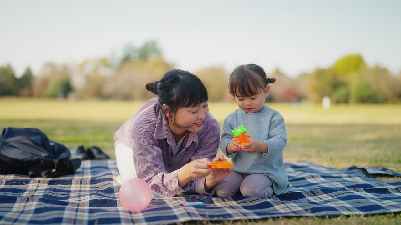 妈妈和小女儿在公园里玩泡泡视频素材