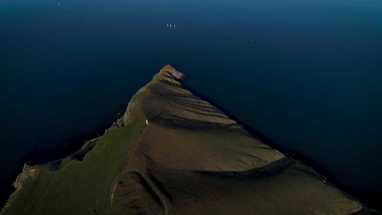 葡萄牙亚速尔群岛，圣乔治岛，沿海的绿色山丘和深蓝色平静的大西洋的鸟瞰图。射杀。被绿色草地和美丽海洋覆盖的令人惊叹的山视频素材