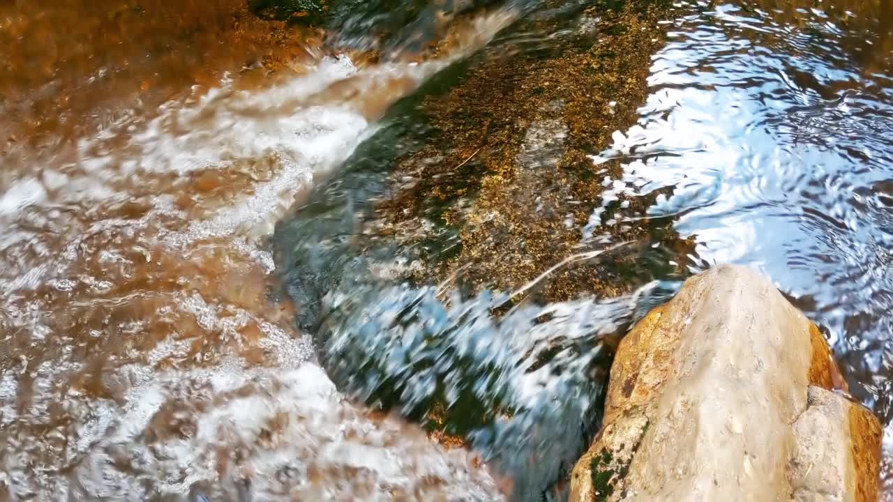 在一块石头上的特写镜头，清澈的水在流动视频素材