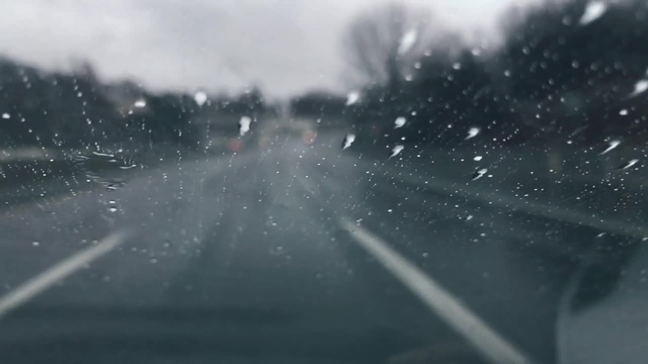 在雨中开车，雨滴在挡风玻璃上移动视频素材